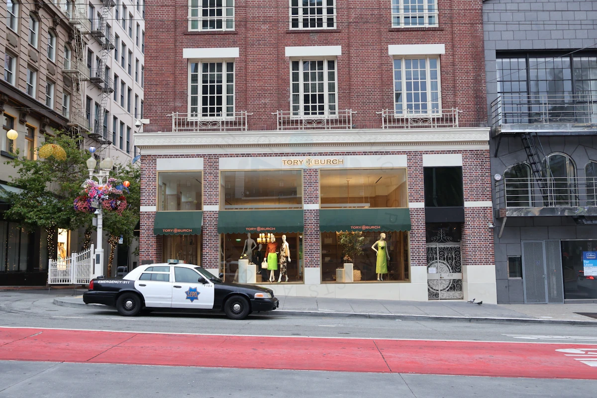 Storefront, pedestrians, and a vehicle illustrating visual clues for reverse video research